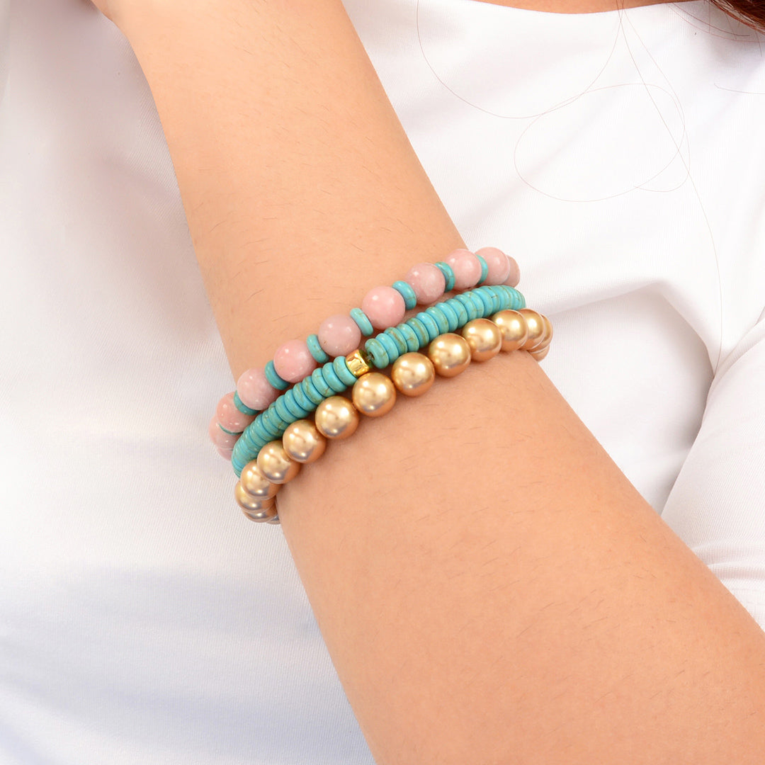 Three beaded bracelets on a wrist against a white background