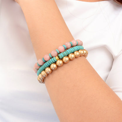 Three beaded bracelets on a wrist against a white background