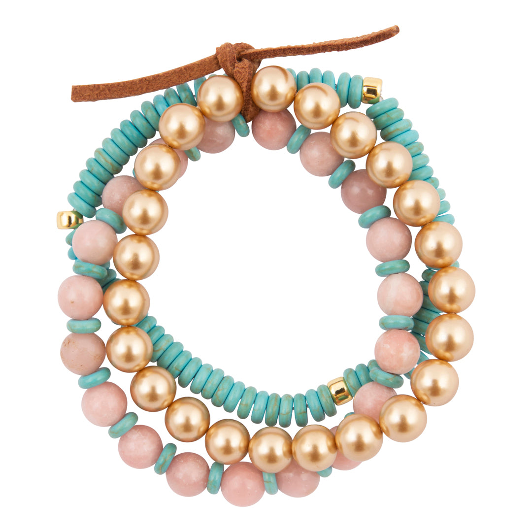 Set of three beaded bracelets with gold, pink, and turquoise beads on a white background