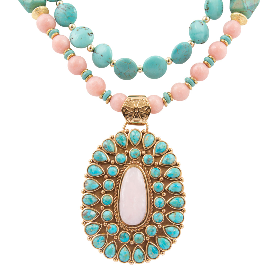 Necklace with turquoise and pink beads and a decorative pendant on a white background