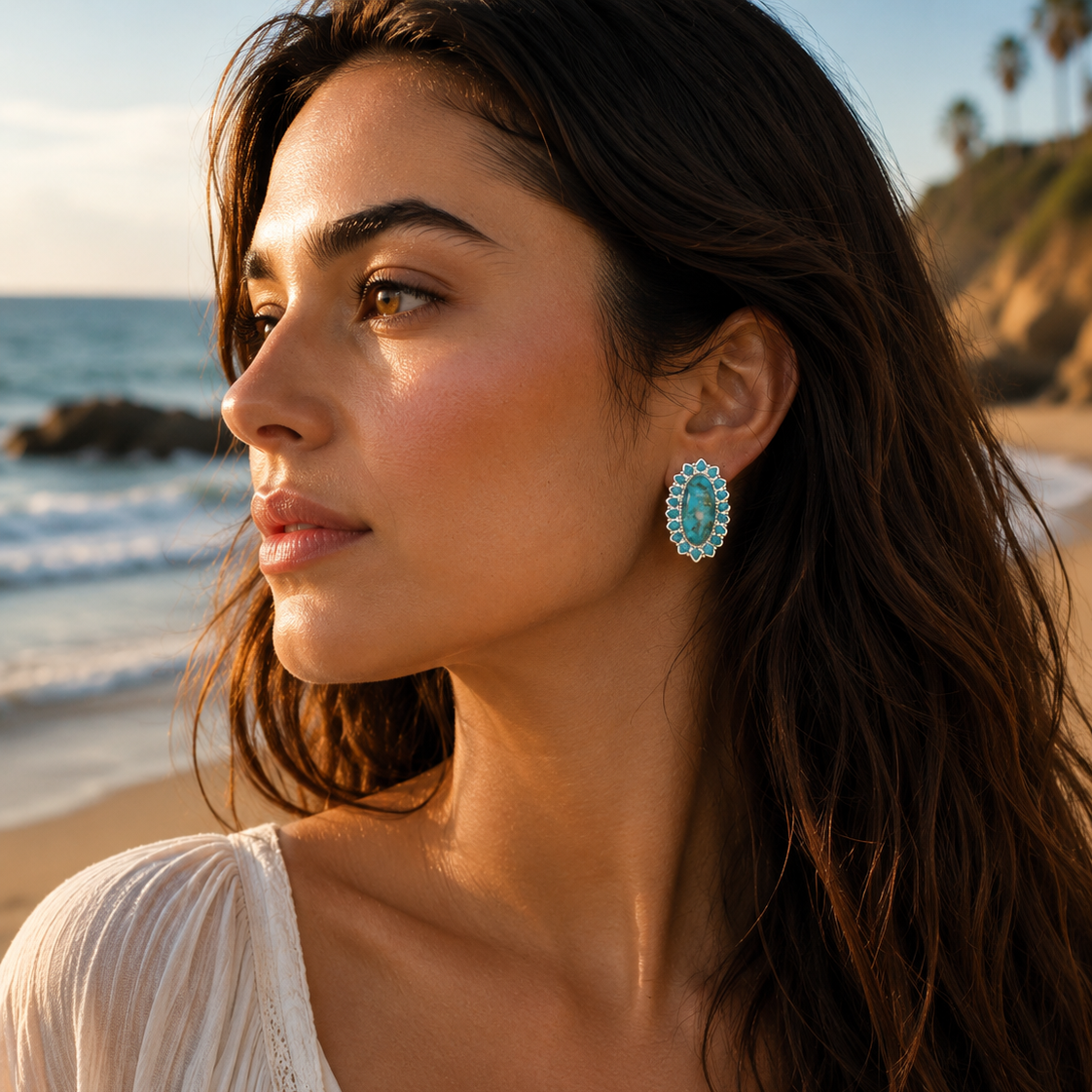 Woman wearing turquoise earrings on a beach