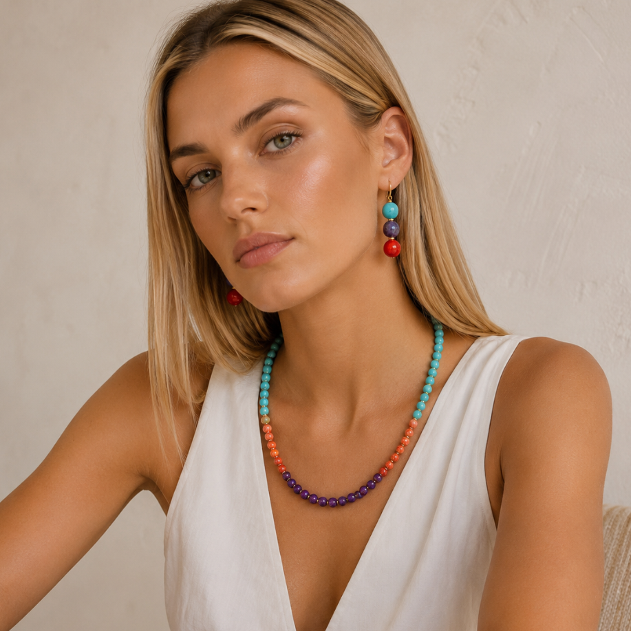 Woman wearing colorful jewelry against a neutral background