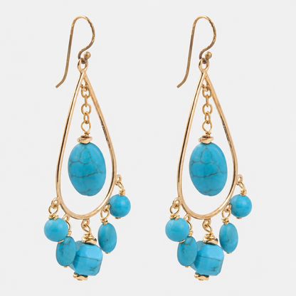 A pair of gold teardrop dangle earrings featuring large oval turquoise beads and smaller dangling turquoise beads, shown against a light gray background.