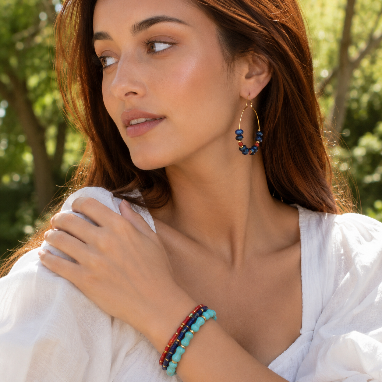 Woman wearing colorful beaded earrings and bracelets outdoors
