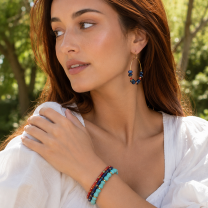 Woman wearing colorful beaded earrings and bracelets outdoors