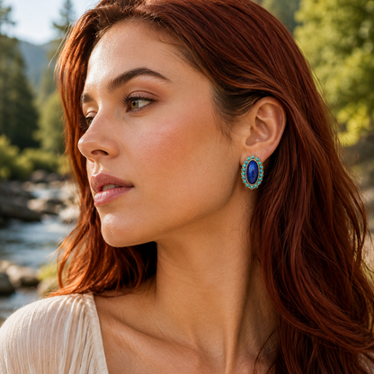 Woman with red hair wearing blue earrings in a natural setting