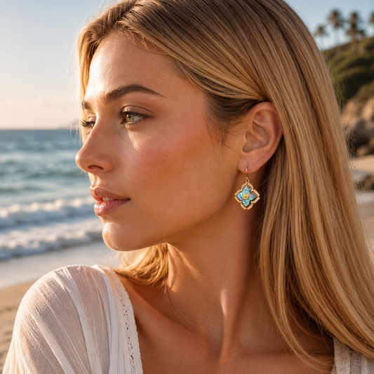 Woman wearing earrings with a beach and ocean in the background