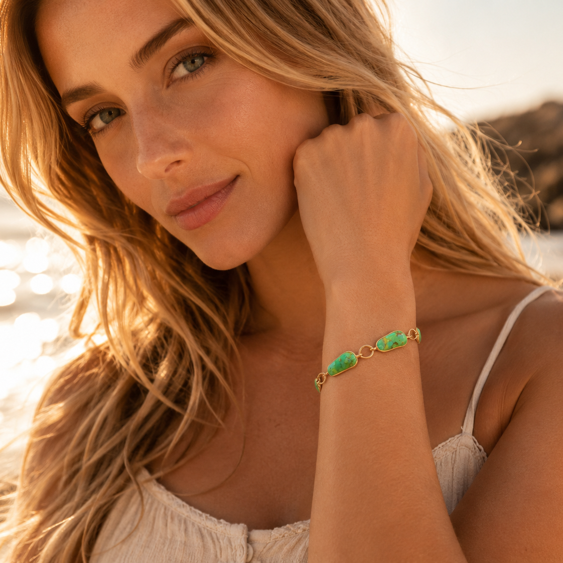 Woman on a beach with a scenic background, wearing a bracelet.