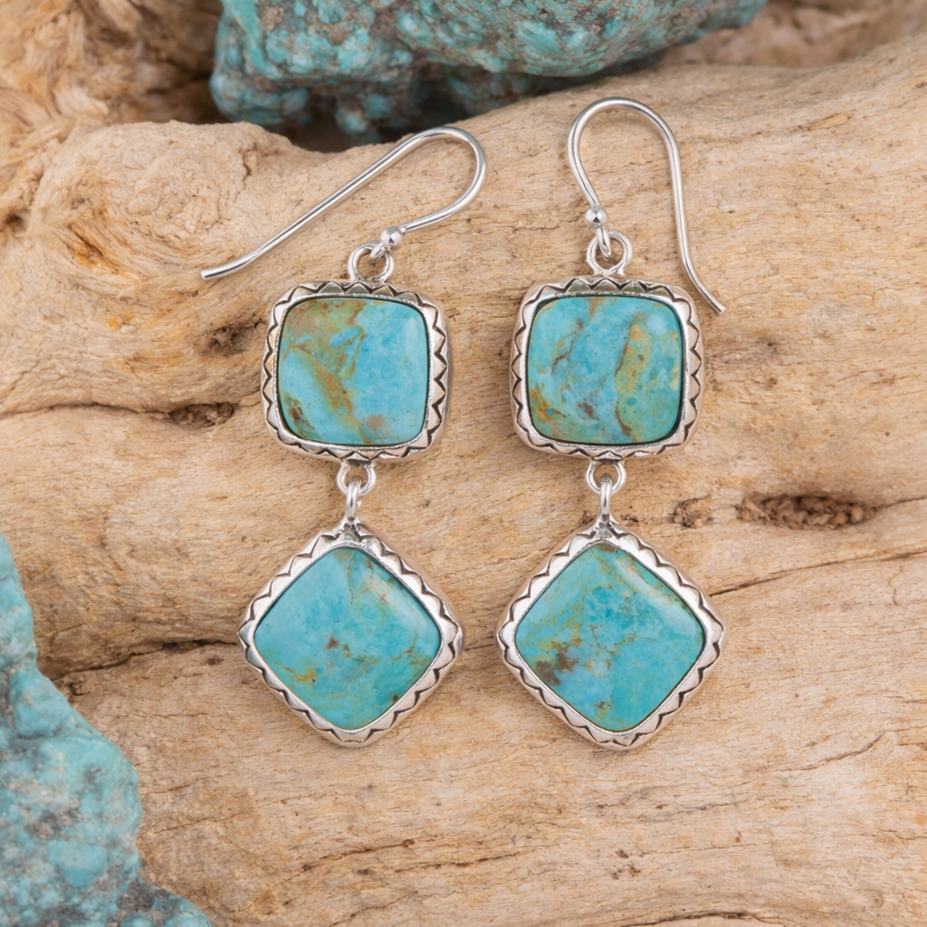 Turquoise earrings with silver settings on a wooden surface