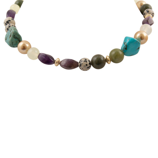 A beaded necklace featuring a mix of natural stones and pearls in turquoise, purple, olive green, cream, and gold spacers, shown against a plain white background.