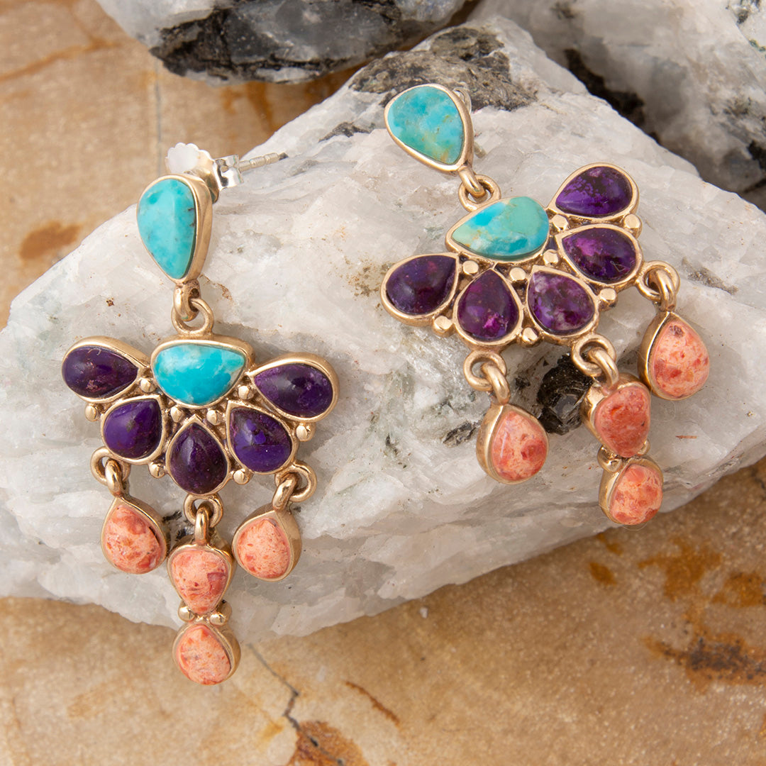 Colorful gemstone earrings on a stone surface