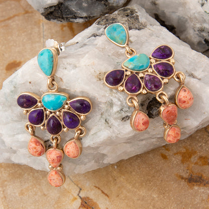 Colorful gemstone earrings on a stone surface