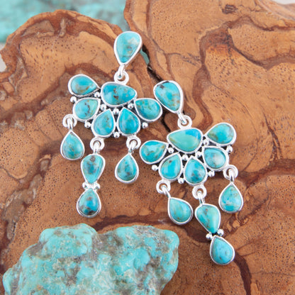 Turquoise earrings on a textured stone surface
