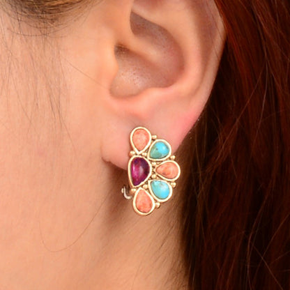 Multicolored gemstone earring worn by a person with red hair.