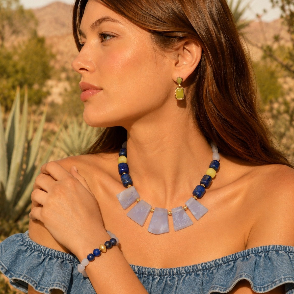 Woman wearing a blue necklace and earrings with a desert background