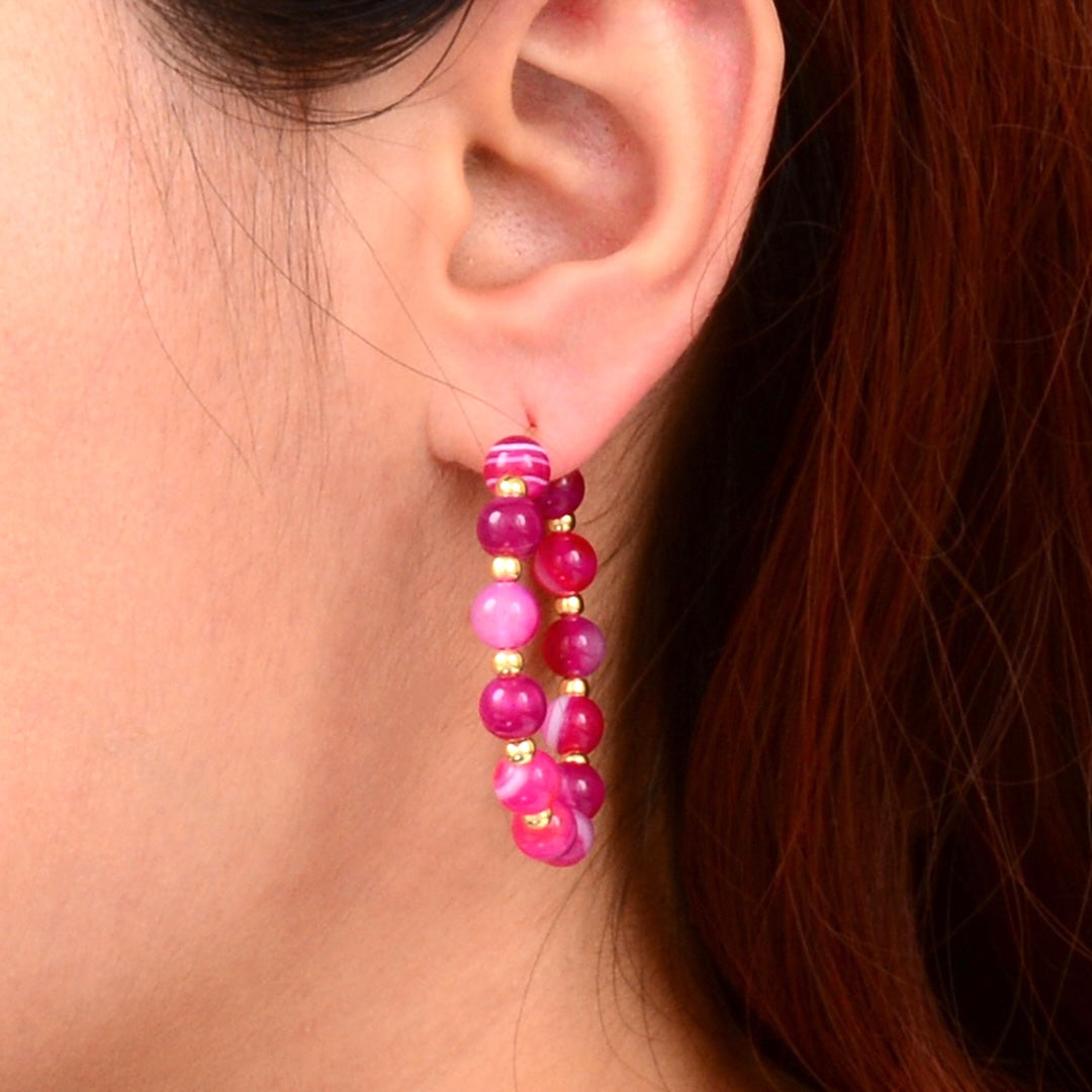Close-up of an ear wearing a colorful beaded earring with a blurred background