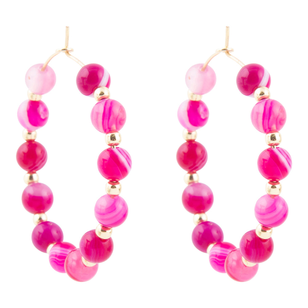 Pair of pink beaded hoop earrings on a white background