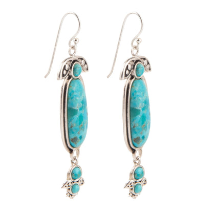 Turquoise stone earrings with silver accents on a white background