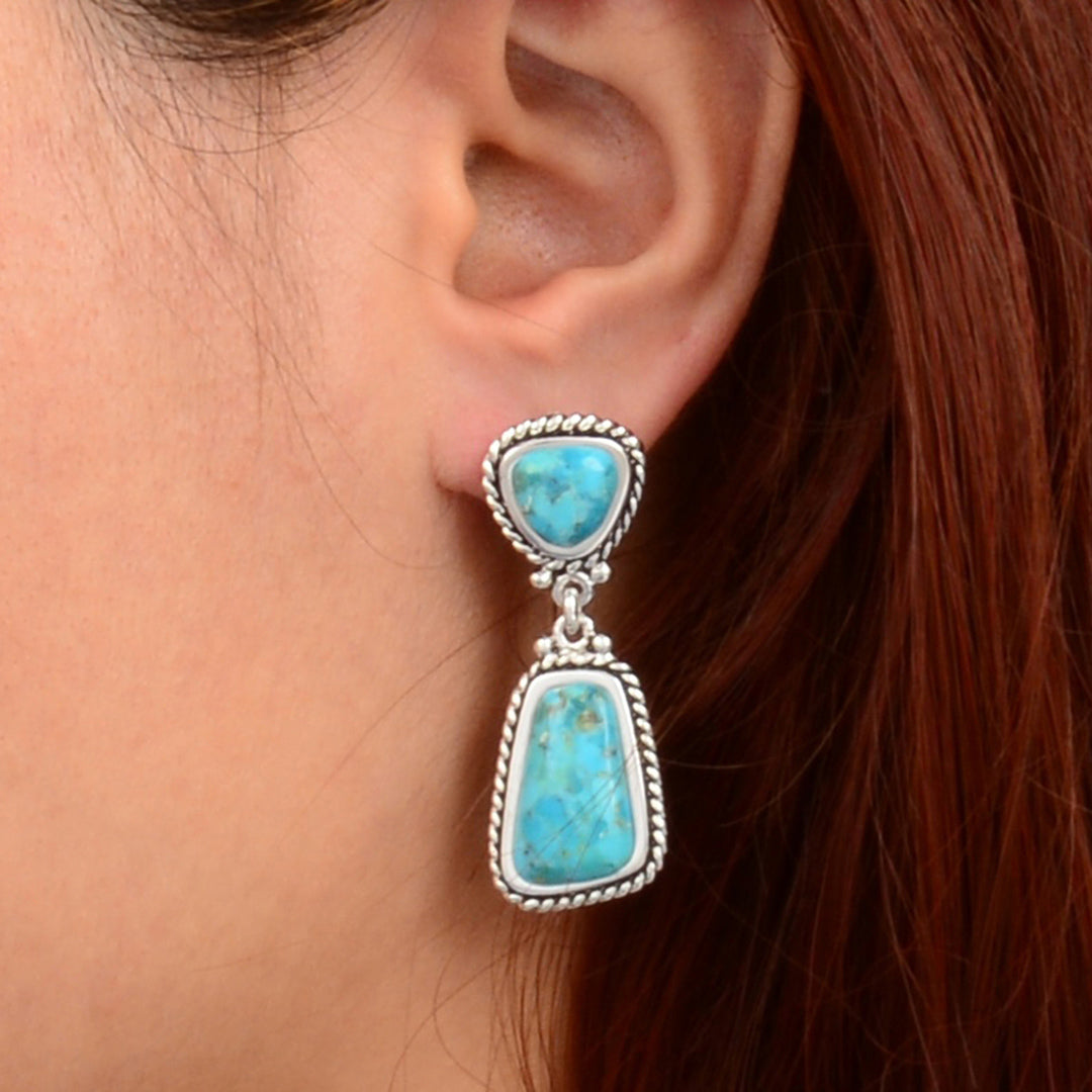 Turquoise earring worn by a person with red hair