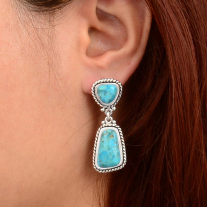 Turquoise earring worn by a person with red hair