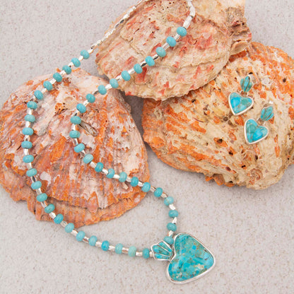 Turquoise beaded necklace with heart-shaped pendants on seashells.