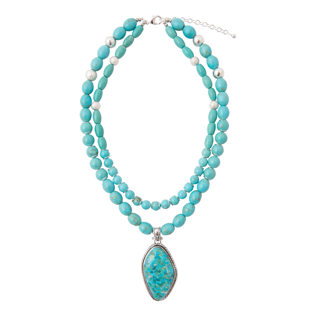 A multi-strand turquoise beaded necklace with a large teardrop-shaped turquoise pendant in a silver bezel setting, displayed on a clean white background.
