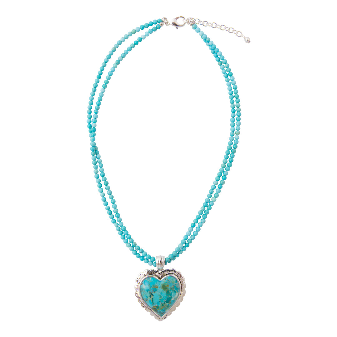 A double-strand turquoise beaded necklace with a heart-shaped turquoise pendant in a silver-toned frame, displayed on a clean white background.