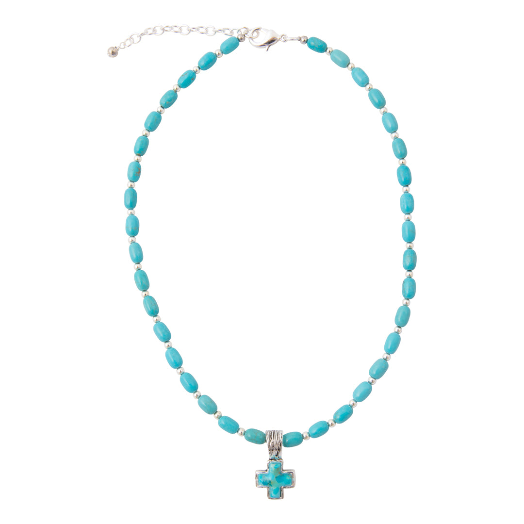 A turquoise beaded necklace with a silver-toned cross pendant, displayed on a clean white background.