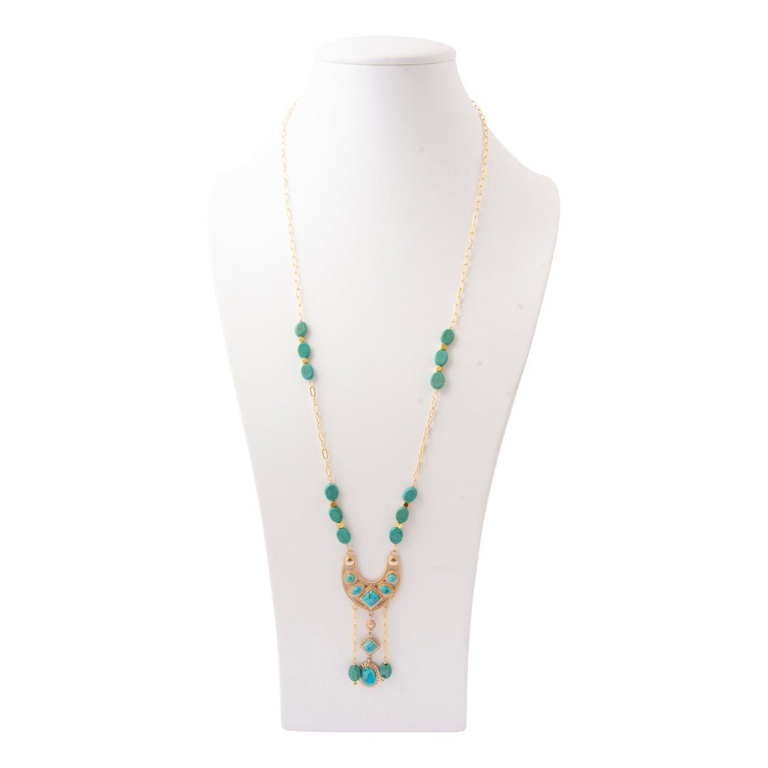 A gold-tone beaded necklace with turquoise blue-green beads and a crescent moon pendant, displayed on a white mannequin bust against a white background.