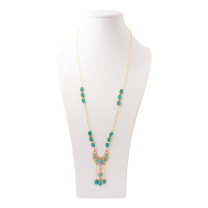 A gold-tone beaded necklace with turquoise blue-green beads and a crescent moon pendant, displayed on a white mannequin bust against a white background.