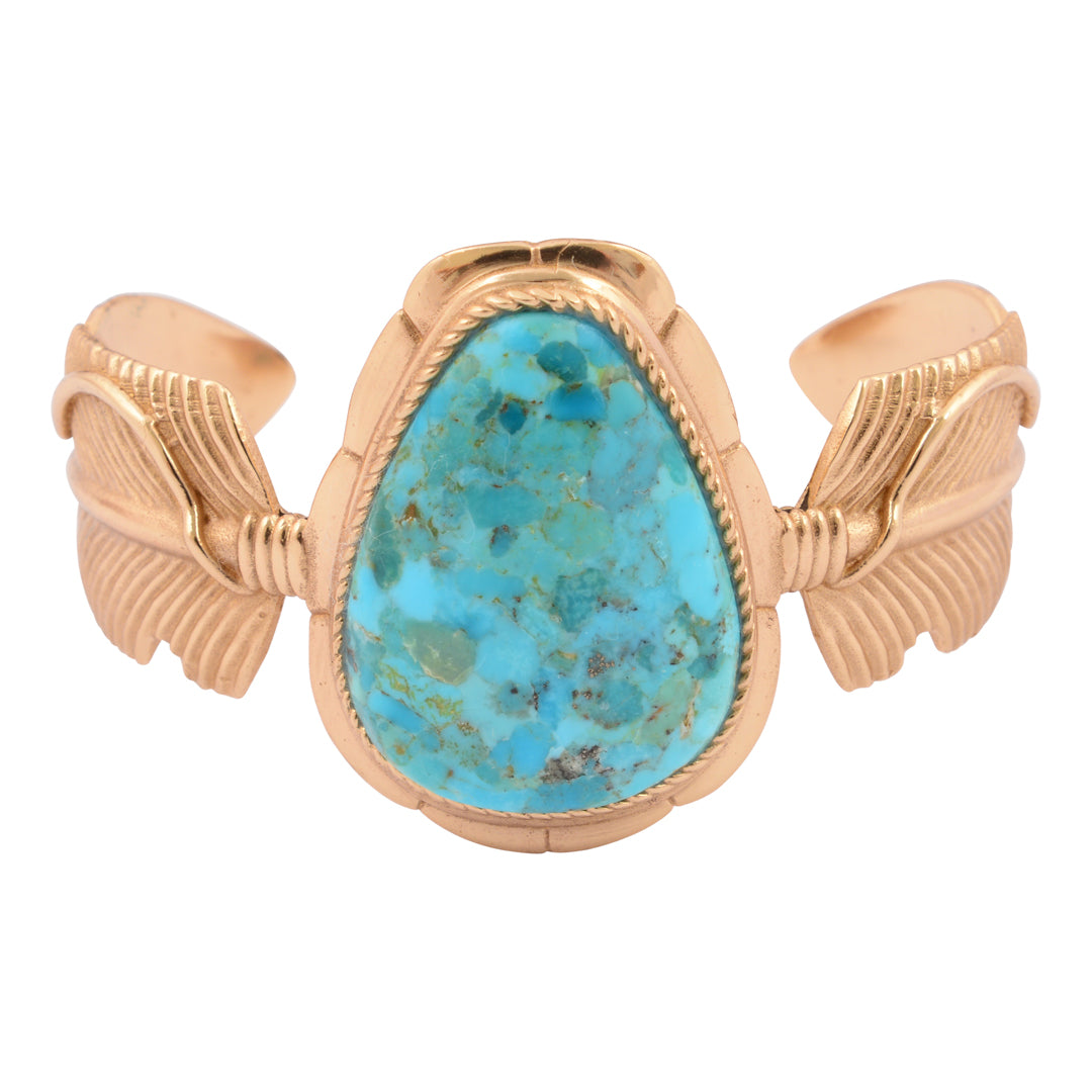 Gold bracelet with a turquoise stone on a white background