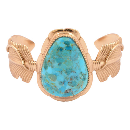 Gold bracelet with a turquoise stone on a white background