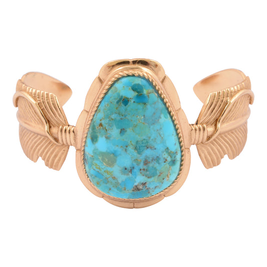 Gold bracelet with a turquoise stone on a white background