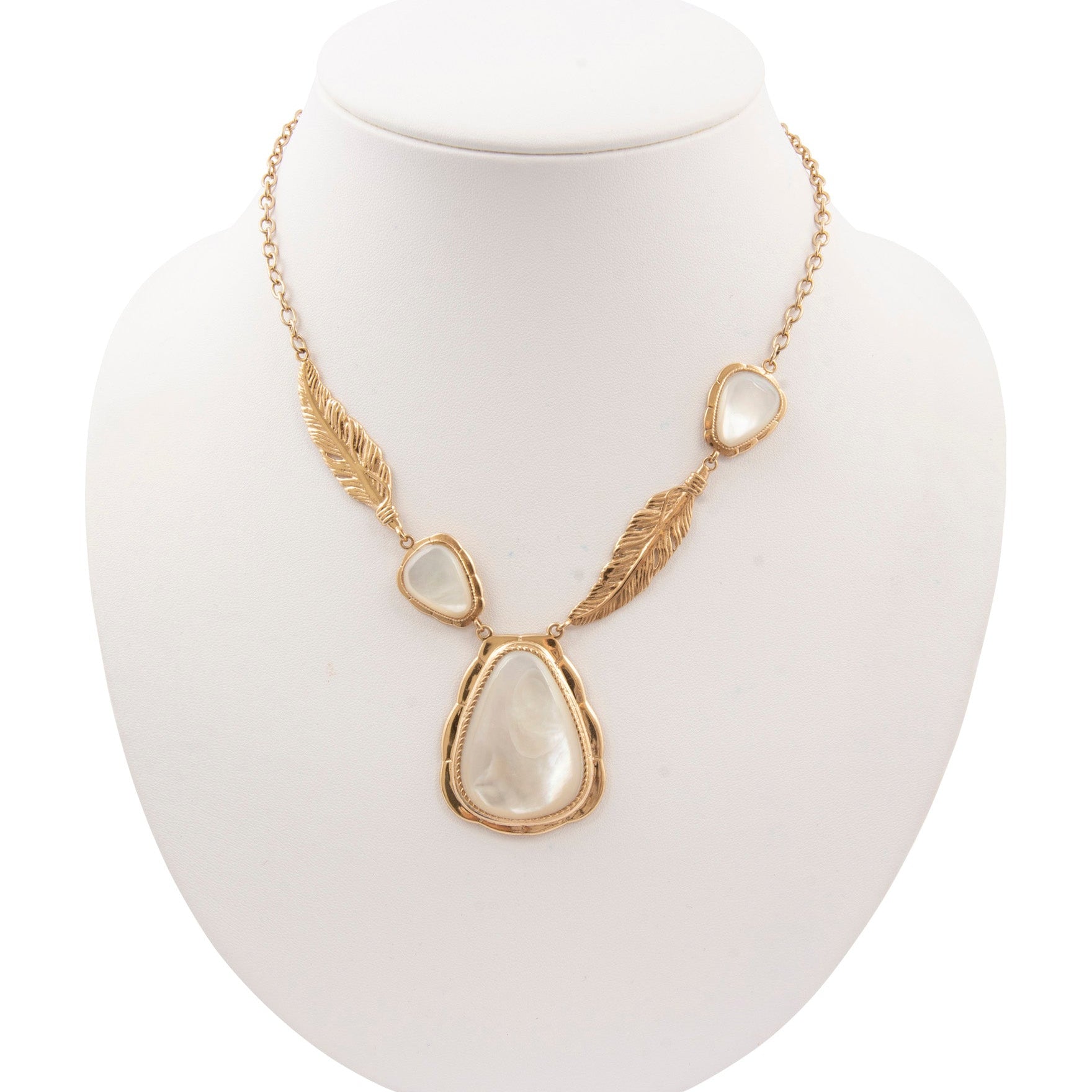 Gold necklace with stone pendants on a white mannequin bust