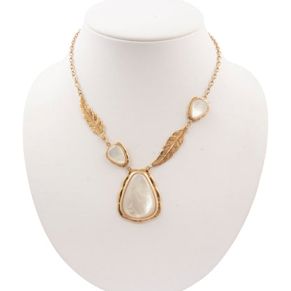 Gold necklace with stone pendants on a white mannequin bust