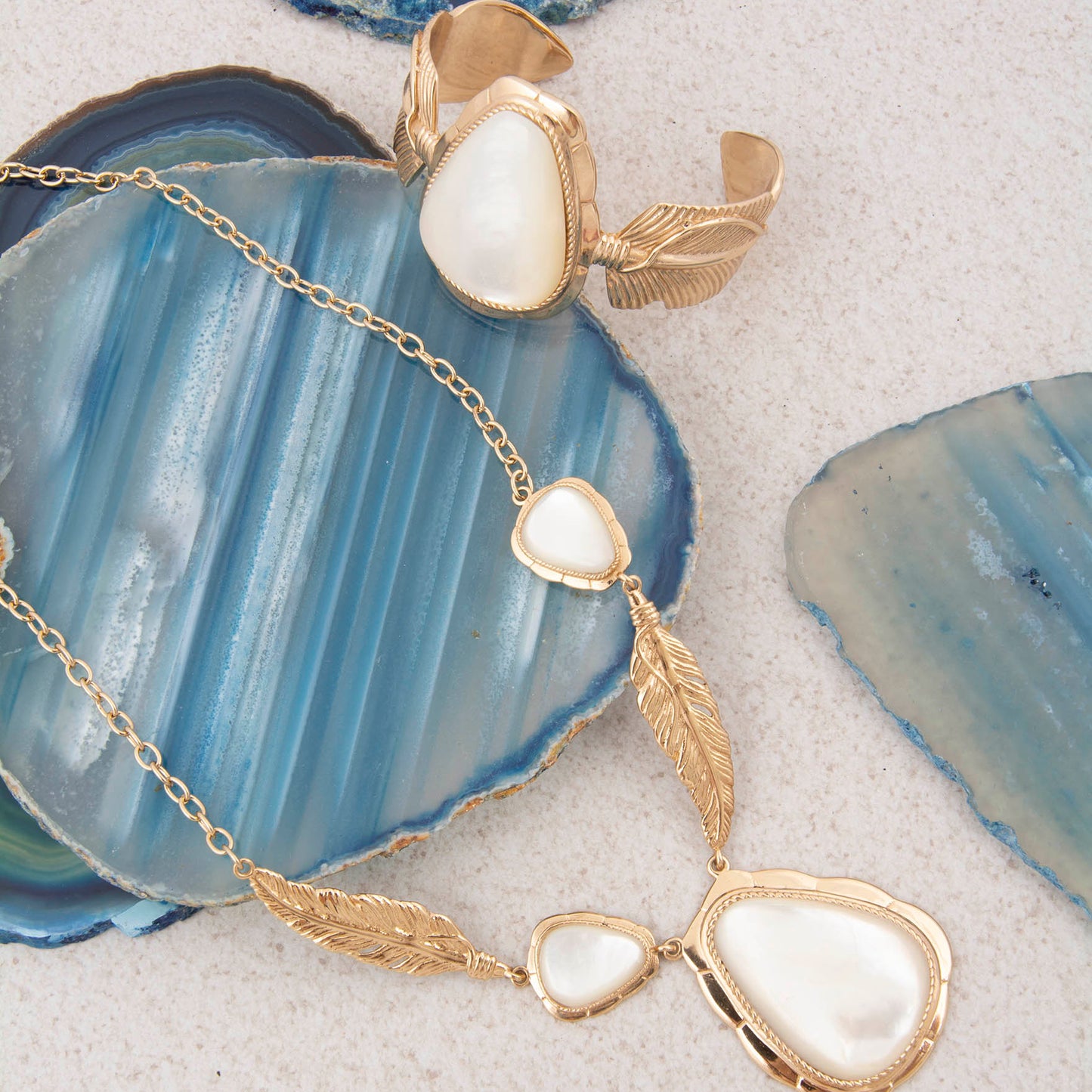 Gold necklace with heart-shaped pendants on a blue agate stone
