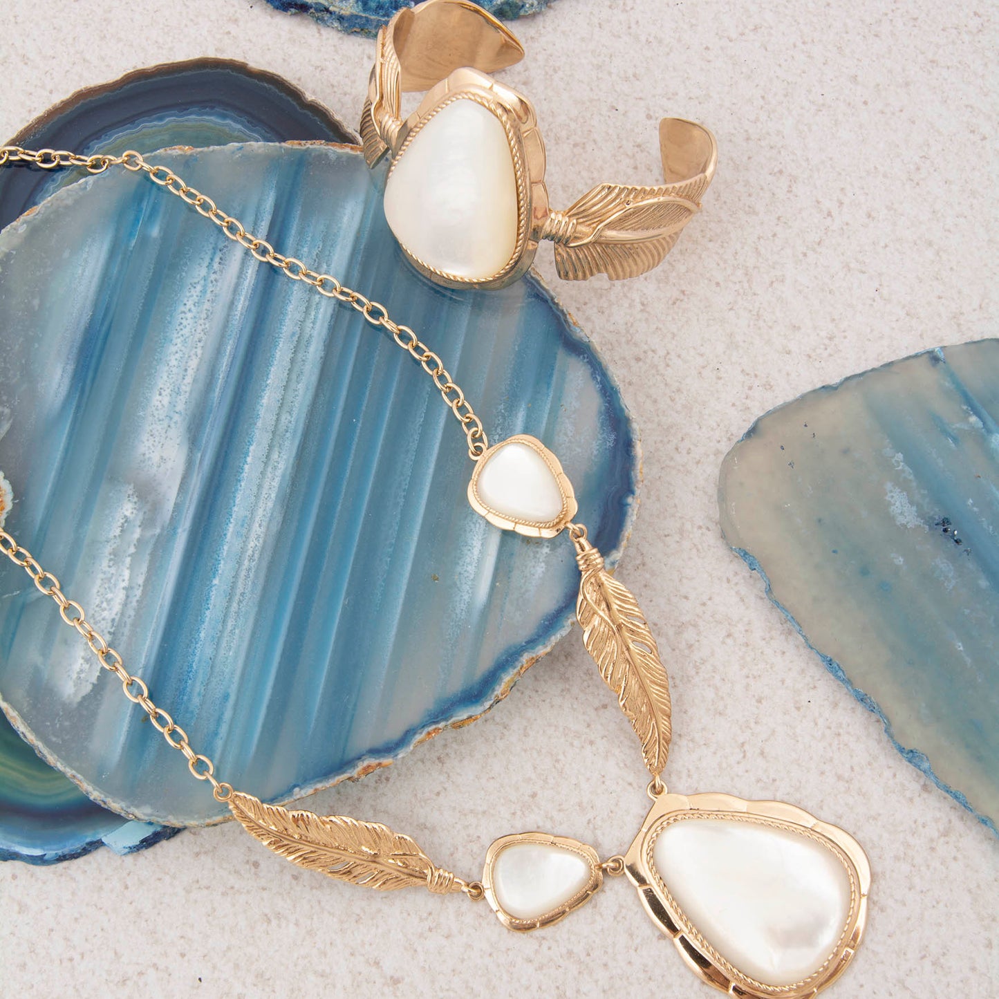 Gold necklace with heart-shaped pendants on a blue agate stone