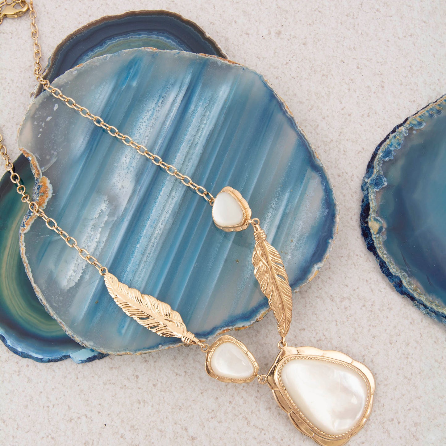Gold necklace with white stones on a blue agate stone