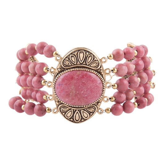 A multi-strand beaded bracelet featuring pink stone beads and a central oval pink stone set in an ornate gold-toned metal frame, shown on a plain white background.