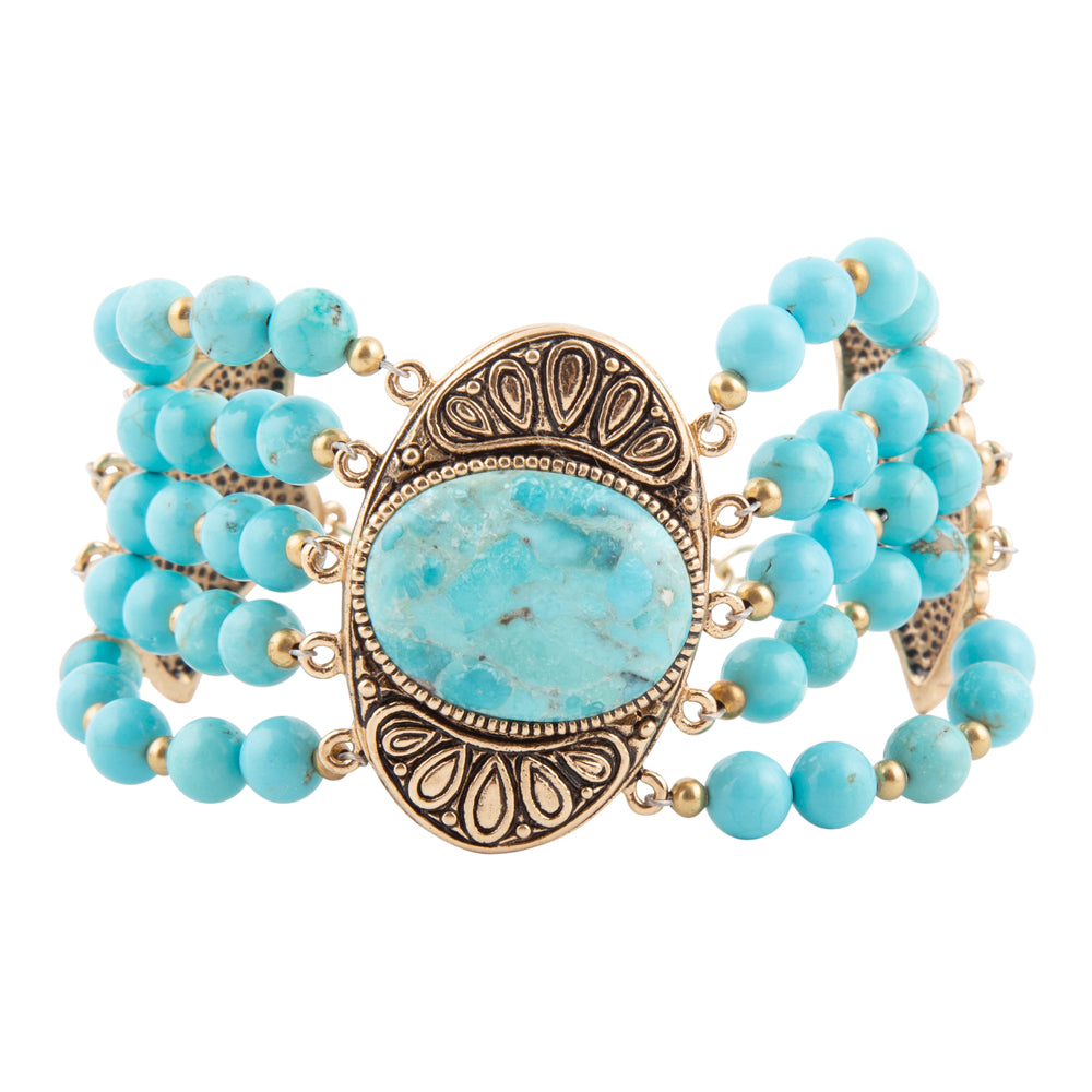 A multi-strand turquoise beaded wrap bracelet with a large central oval turquoise stone and an ornate antique bronze-tone metal frame, shown on a plain white background.