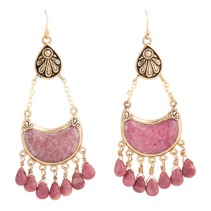 A pair of gold-toned dangle earrings featuring a crescent-shaped pink stone inlay and multiple dangling teardrop beads at the bottom, shown against a plain white background.