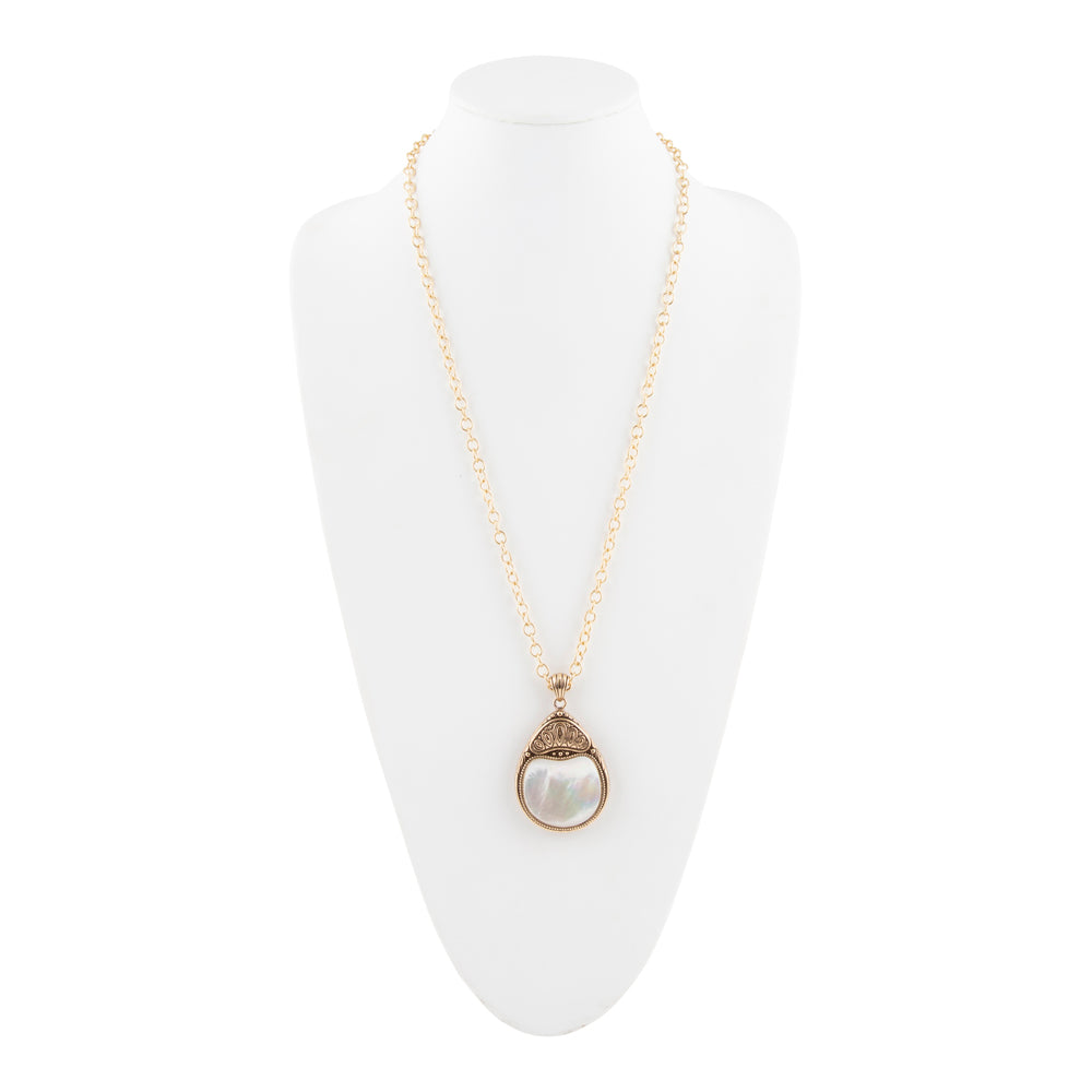A gold chain necklace with a teardrop-shaped pendant featuring a white pearl-like center and a textured gold border, displayed on a white mannequin bust against a white background.