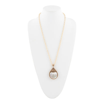 A gold chain necklace with a teardrop-shaped pendant featuring a white pearl-like center and a textured gold border, displayed on a white mannequin bust against a white background.