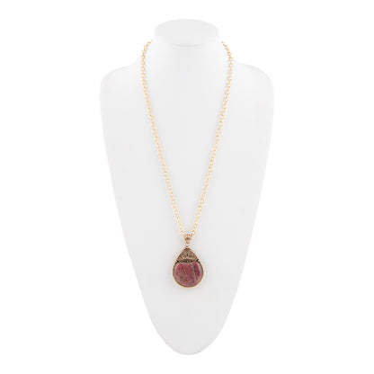 A gold chain necklace with a teardrop-shaped pendant featuring a pinkish-red stone and a textured gold cap, displayed on a white mannequin bust against a white background.