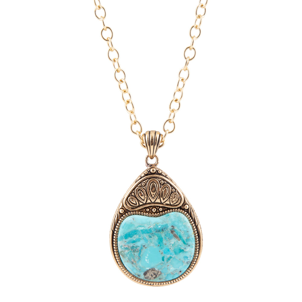 A gold-tone chain necklace with an ornate teardrop pendant featuring a light blue turquoise stone in a textured, antique-style gold bezel setting, shown against a plain white background.