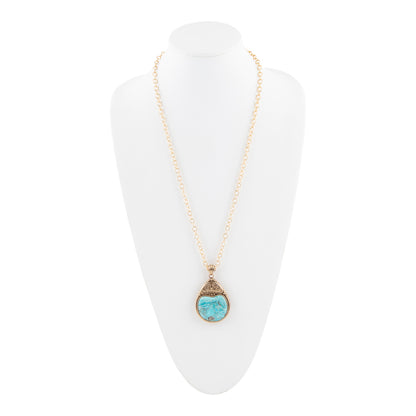 A gold chain necklace with a teardrop-shaped pendant featuring a light blue stone and textured gold settings, displayed on a white neck mannequin.