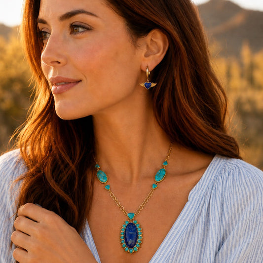 Woman wearing a blue necklace and earrings with a scenic background