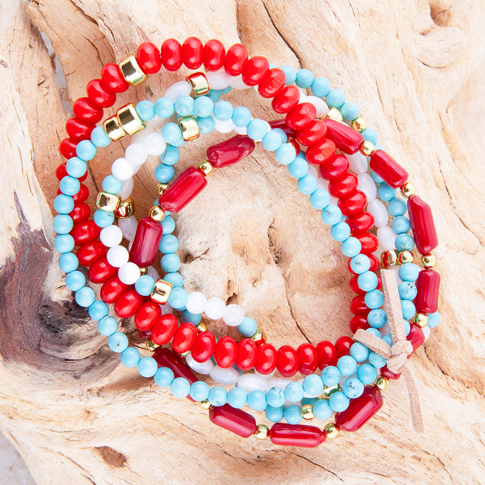 Set of red, blue, and white beaded bracelets on a wooden surface