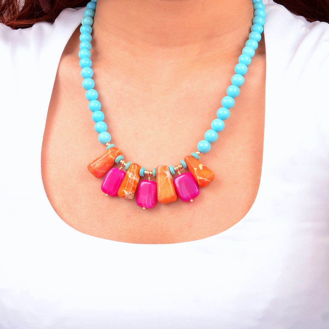 Necklace with turquoise beads and colorful rectangular beads on a white background