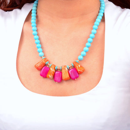 Necklace with turquoise beads and colorful rectangular beads on a white background